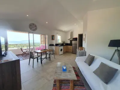 a living room with a white couch and a table at Très belle Résidence vue mer et piscine chauffée - BACCALOCATION in Porto-Vecchio