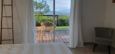 a bedroom with a bed and a view of a balcony at Très belle Résidence vue mer et piscine chauffée - BACCALOCATION in Porto-Vecchio