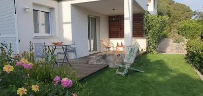 a patio with a table and chairs in a yard at Très belle Résidence vue mer et piscine chauffée - BACCALOCATION in Porto-Vecchio