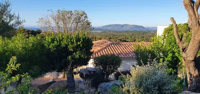 a view of a house with a mountain in the background at Très belle Résidence vue mer et piscine chauffée - BACCALOCATION in Porto-Vecchio