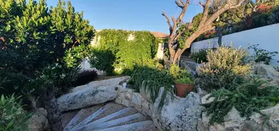 a garden with some plants and trees and rocks at Très belle Résidence vue mer et piscine chauffée - BACCALOCATION in Porto-Vecchio