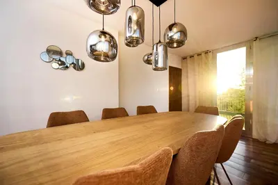 a dining room with a wooden table and chairs at Hôtel Les Jardins in Lucciana