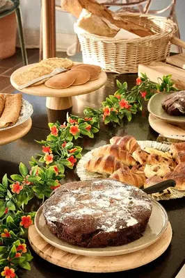 a table topped with different types of bread and pastries at Hôtel Les Jardins in Lucciana