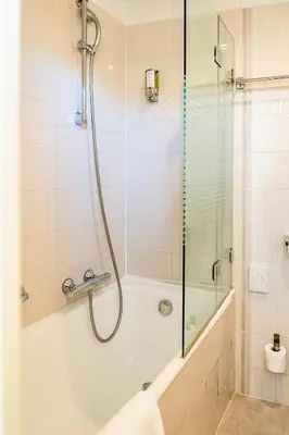 a bathroom with a shower and a bath tub with a glass door at Hôtel Du Golfe in Ajaccio