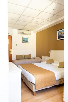 a bedroom with three beds in a room at Hôtel Du Golfe in Ajaccio