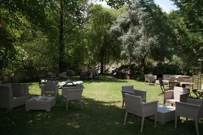 a group of chairs and tables in a park at Les Jardins De La Glacière in Corte