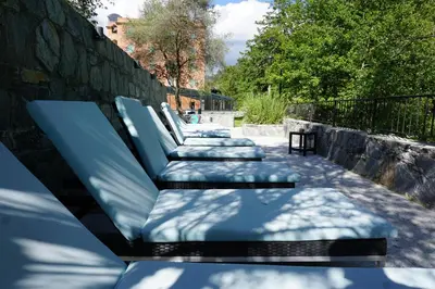 a row of blue benches sitting next to a wall at Les Jardins De La Glacière in Corte