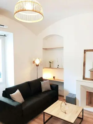 a living room with a black couch and a coffee table at T2 COSY EN PLEIN CENTRE HISTORIQUE D'AJACCIO in Ajaccio