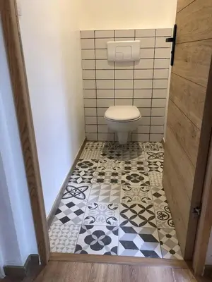 a bathroom with a toilet and a black and white tile floor at T2 COSY EN PLEIN CENTRE HISTORIQUE D'AJACCIO in Ajaccio