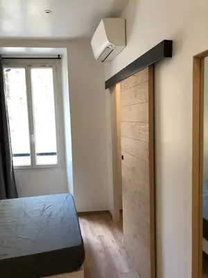 a bedroom with a bed and a window and a door at T2 COSY EN PLEIN CENTRE HISTORIQUE D'AJACCIO in Ajaccio