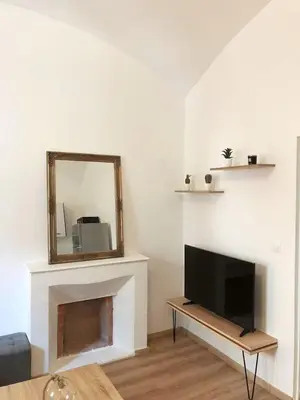 a living room with a mirror and a tv at T2 COSY EN PLEIN CENTRE HISTORIQUE D'AJACCIO in Ajaccio