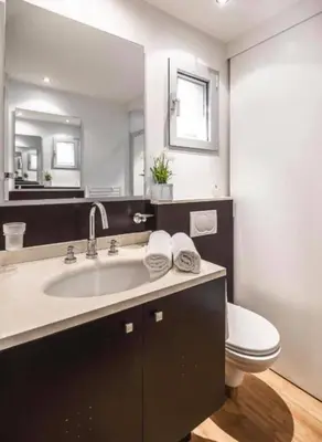 a bathroom with a sink and a toilet and a mirror at Porto-Vecchio Baie Santa Giulia appartement une chambre 4-5 personnes in Porto-Vecchio