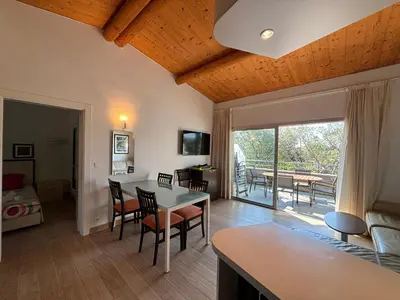 a living room with a table and chairs and a dining room at Porto-Vecchio Baie Santa Giulia appartement une chambre 4-5 personnes in Porto-Vecchio