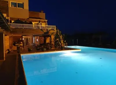 a large swimming pool in front of a building at night at Levolle Marine in Poggio-Mezzana