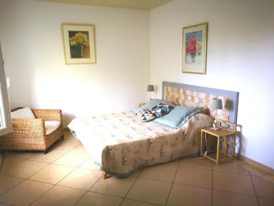 a bedroom with a bed and a chair in it at Levolle Marine in Poggio-Mezzana