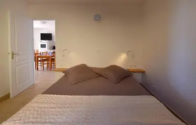 a bedroom with a bed and a dining room at Résidence Chiar' Di Luna in Sainte-Lucie de Porto-Vecchio