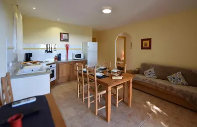 a kitchen and living room with a table and a couch at Résidence Chiar' Di Luna in Sainte-Lucie de Porto-Vecchio