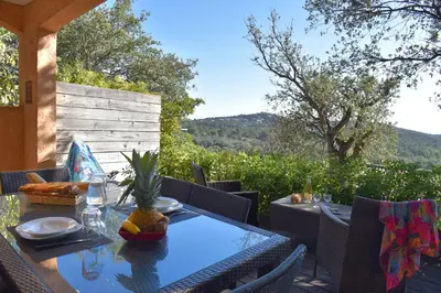 a table and chairs on a patio with a view at Résidence Chiar' Di Luna in Sainte-Lucie de Porto-Vecchio