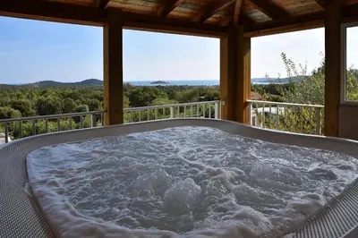 a jacuzzi tub on the porch of a house at Résidence Chiar' Di Luna in Sainte-Lucie de Porto-Vecchio