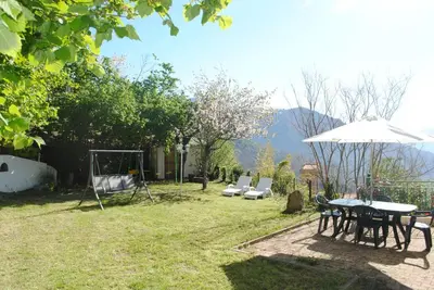 a patio with a table and chairs and an umbrella at MAISON TUCCARELLU in Letia