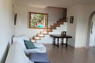 a living room with a couch and stairs with a table at MAISON TUCCARELLU in Letia