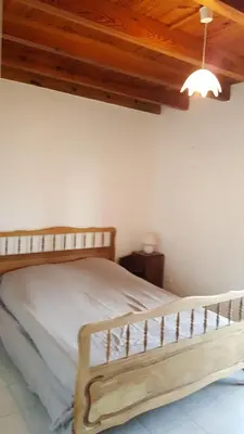 a bed in a bedroom with a wooden ceiling at MAISON TUCCARELLU in Letia