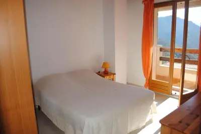 a bedroom with a bed and a large window at MAISON TUCCARELLU in Letia