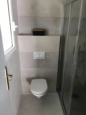 a bathroom with a toilet and a glass shower at Maison Ferruccio in Porto-Vecchio