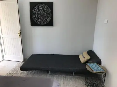 a black couch sitting in a corner of a room at Maison Ferruccio in Porto-Vecchio