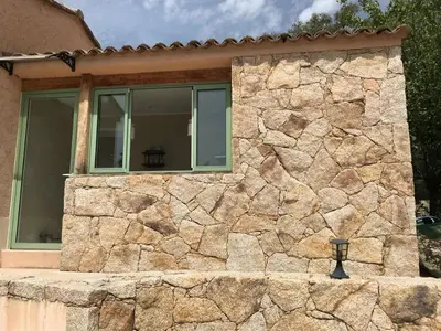a building with a stone wall and a window at Maison Ferruccio in Porto-Vecchio