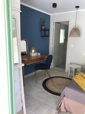 a bedroom with a desk and a blue wall at Maison Ferruccio in Porto-Vecchio