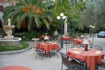 a restaurant with red tables and chairs and a fountain at Castellu Rossu in Lucciana