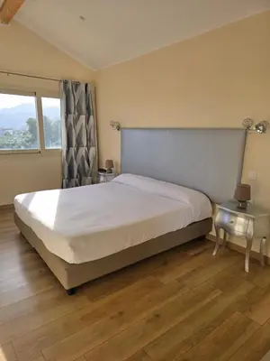 a bedroom with a large bed and a window at Castellu Rossu in Lucciana