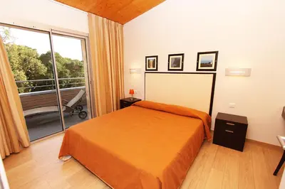 a bedroom with a bed and a large window at Résidence Cala Sultana in Porto-Vecchio