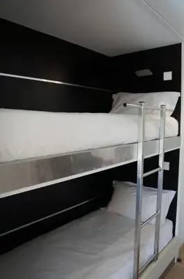 a couple of bunk beds with white sheets and pillows at Résidence Cala Sultana in Porto-Vecchio