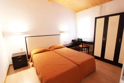 a bedroom with an orange bed and a desk at Résidence Cala Sultana in Porto-Vecchio