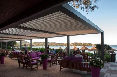 a restaurant with purple chairs and a view of the ocean at Hôtel & Lodges Moby Dick in Porto-Vecchio