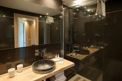 a bathroom with two sinks and a large mirror at Hôtel & Lodges Moby Dick in Porto-Vecchio