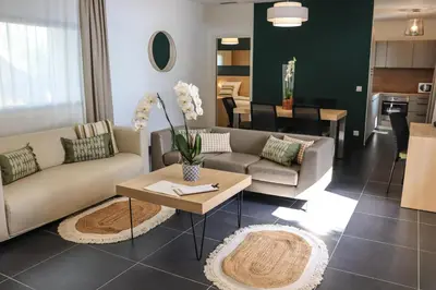 a living room with two couches and a table at Hôtel & Lodges Moby Dick in Porto-Vecchio