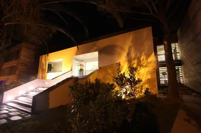 a house lit up at night with a staircase at Hôtel & Lodges Moby Dick in Porto-Vecchio