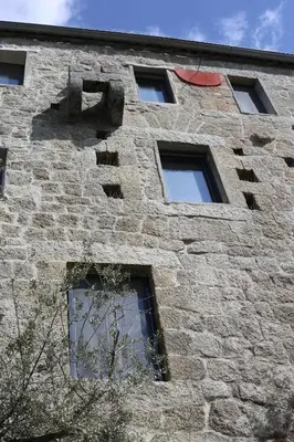 a tall brick building with windows on the side of it at Casa Giacometti in Grosseto-Prugna