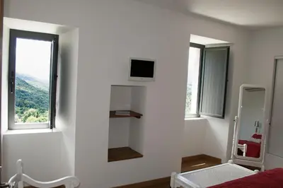a white room with a tv on the wall at Casa Giacometti in Grosseto-Prugna