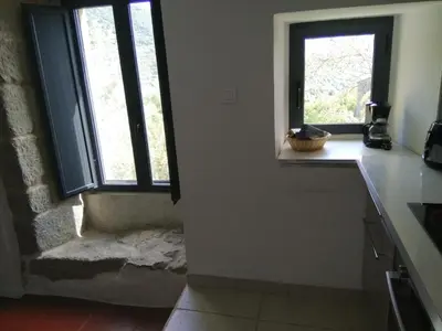 a kitchen with two windows and a counter top at Casa Giacometti in Grosseto-Prugna