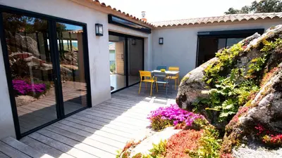 a patio with a table and chairs and flowers at A Camerina in Sotta