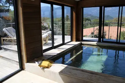 a swimming pool in a house with windows at A Camerina in Sotta