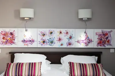 a bedroom with a bed with two pillows and two lights at Hotel Scandola in Piana