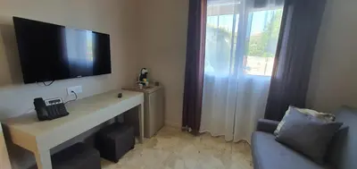 a room with a desk with a television on a wall at Hotel Scandola in Piana