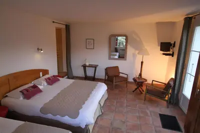 a bedroom with a bed and two chairs and a mirror at Casa Vanella in Casamaccioli