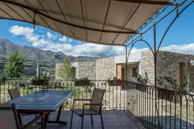 a wooden table and chairs on a patio with mountains at Casa Vanella in Casamaccioli