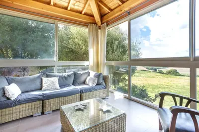 a living room with a couch and large windows at Villa A LICCIA in Figari